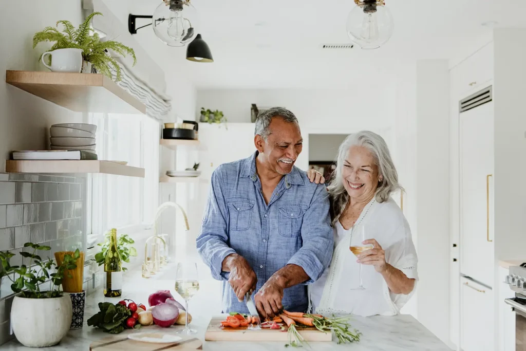 Happy senior couple preparing a meal together, enjoying the freedom of a well-planned retirement
